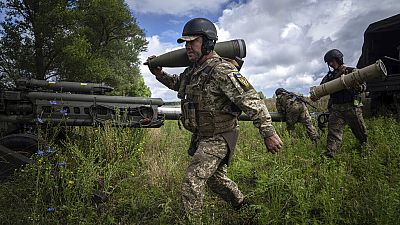 جندي أوكراني يحمل قذيفة مدفعية عيار 155 ملم قبل إطلاق النار على مواقع روسية من مدفع هاوتزر M777 قدمته الولايات المتحدة في منطقة خاركيف، أوكرانيا، الخميس 14 يوليو 2022