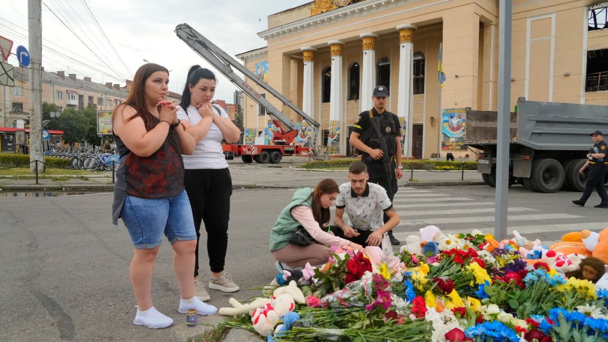 People pray and lay flowers at the site of a Russian shelling on Thursday, in Vinnytsia, Ukraine, Friday, July 15, 2022. Russian missiles killed at least 23 people on Thursday