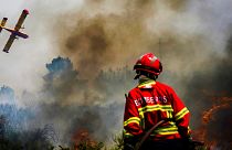 Bombeiro observa avião no combate ao incêndio em Baião, norte de Portugal