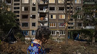Une femme passe devant un bâtiment endommagé à la suite d'une frappe de missile à Konstantinovka, dans l'Oblast de Donetsk, dans l'est de l'Ukraine, vendredi 15 juillet 2022.