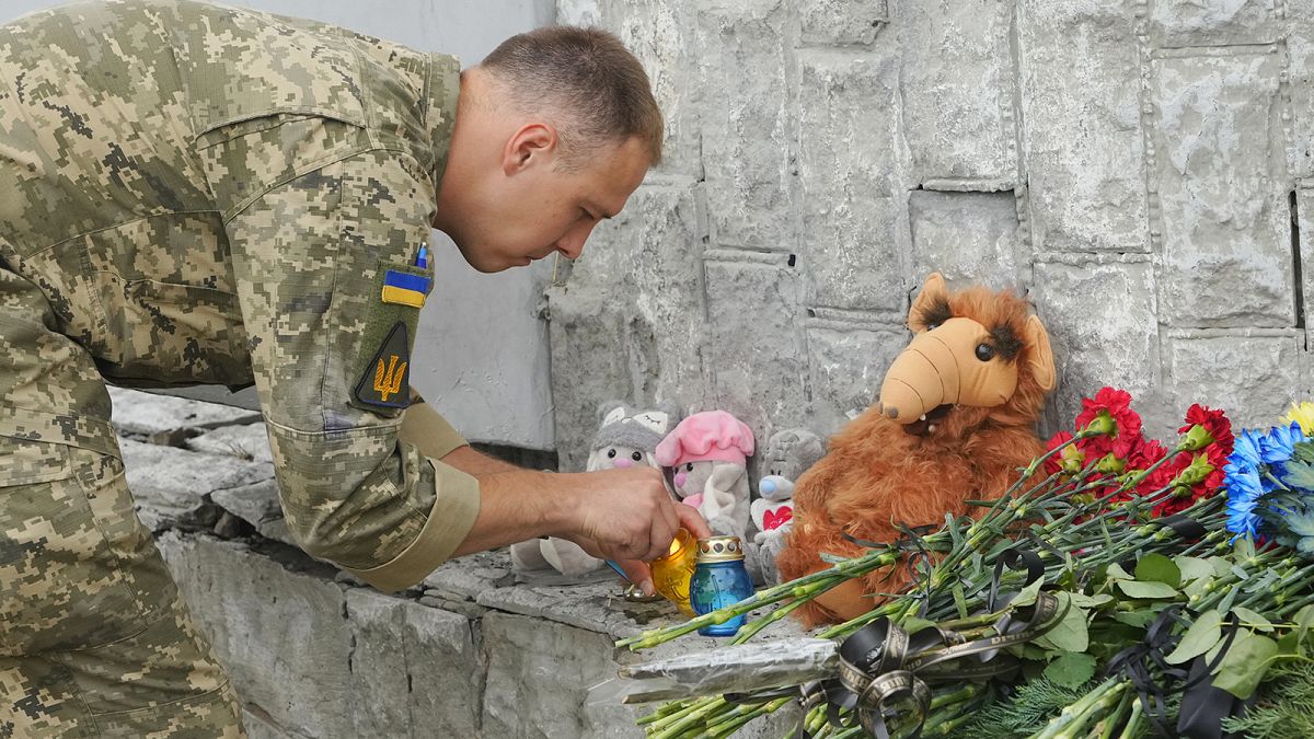 Ukrainian serviceman lights a candle at the site of a Russian shelling on Thursday, in Vinnytsia, 15 July 2022