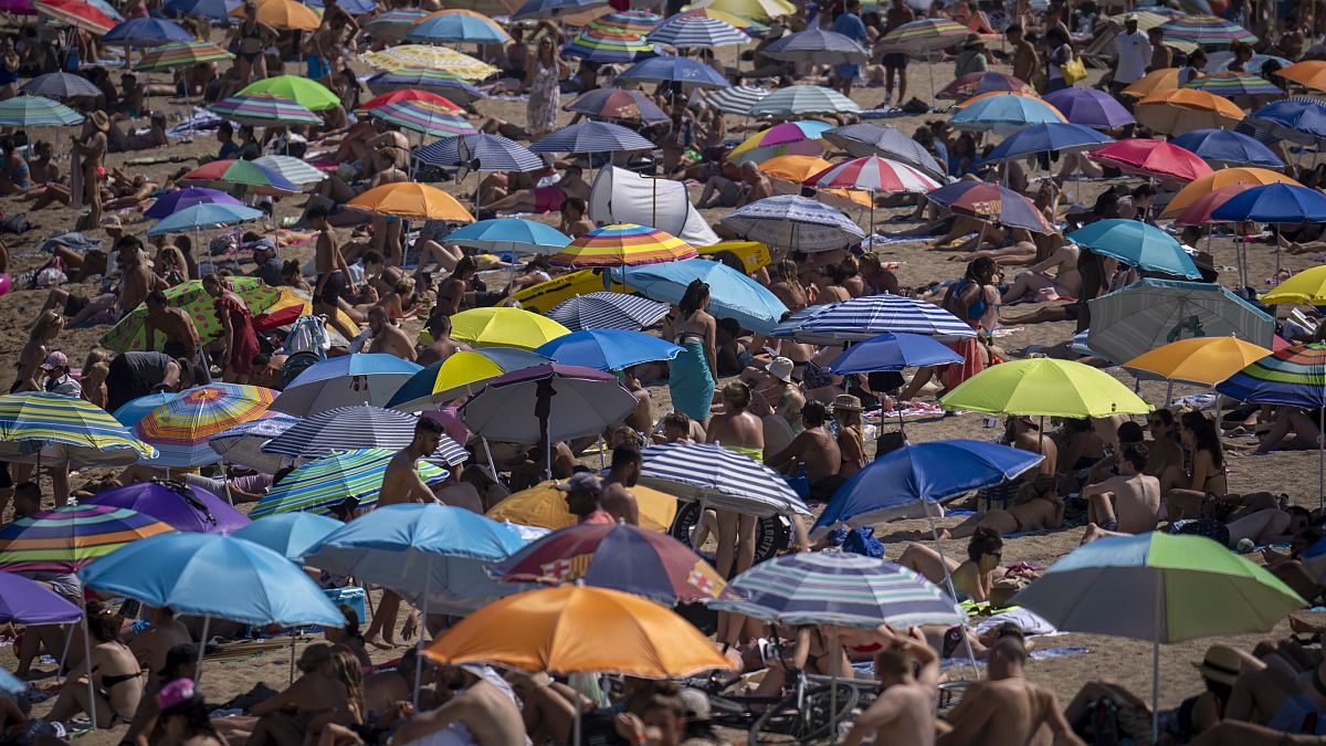 مظلات شمسية على شاطىء في برشلونة، إسبانيا.