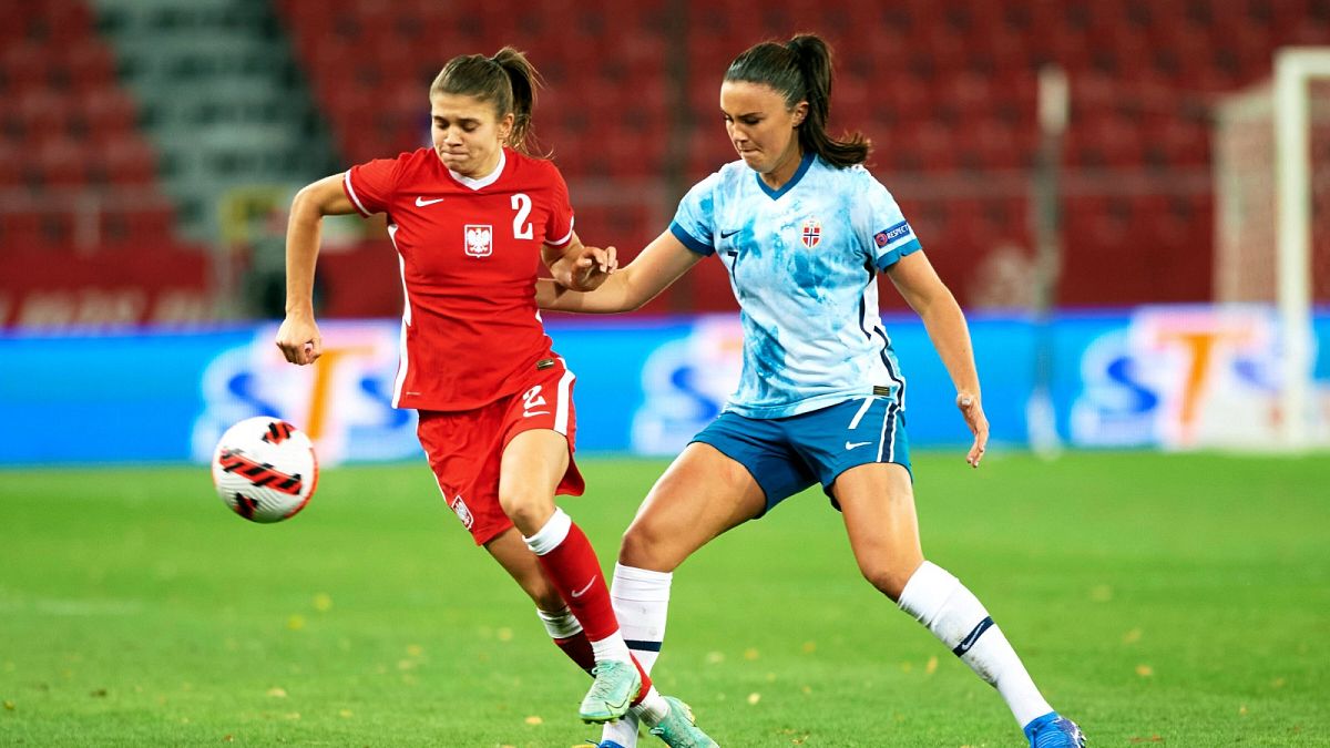 Poland's Martyna Wiankowska, left, is challenged by Norway's Ingrid Syrstad Engen during Women's World Cup qualifying football match in Poland, October 2021.