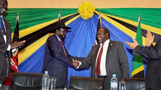  رئيس جنوب السودان سلفا كير، إلى اليسار، يصافح رياك مشار، على اليمين، بعد توقيع اتفاق في نهاية المحادثات في أروشا، تنزانيا، 21 يناير 2015 