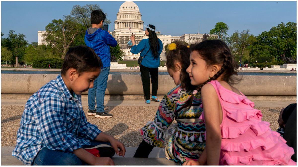 أطفال أفغان يجلسون مقابل مبنى الكابيتول الأمريكي في واشنطن