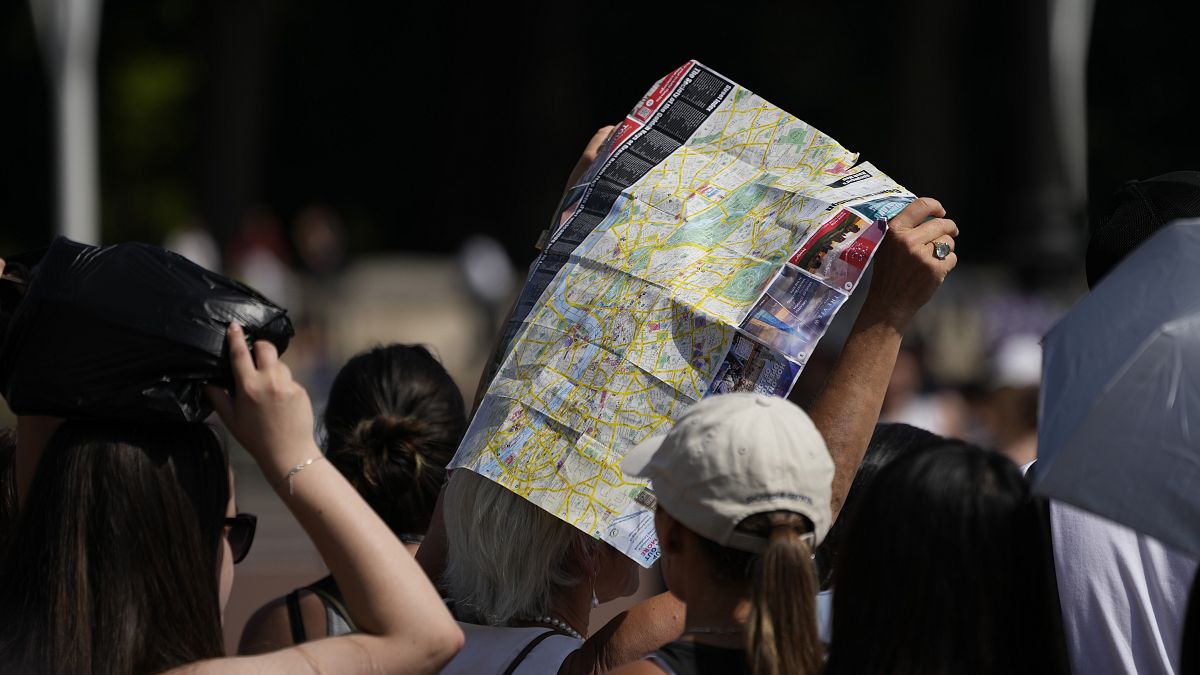 Touristen suchen unter einem Londoner Stadtplan Schatten