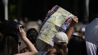 Touristen suchen unter einem Londoner Stadtplan Schatten