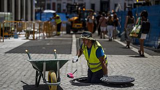 Un ouvrier place des pavés lors d'une journée chaude et ensoleillée à Madrid, en Espagne, lundi 18 juillet 2022.