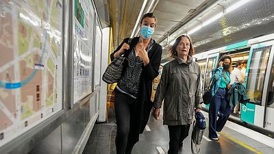 A woman wearing a face mask to protect against COVID-19 rushes on a subway platform in Paris, Thursday, June 30, 2022.