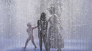Eine Familie erfrischt sich in einem Stadtbrunnen an der South Bank in London, Dienstag 19. Juli 2022.
