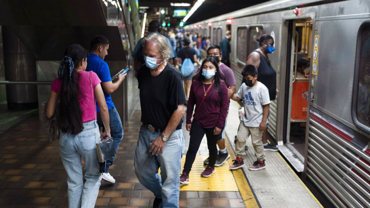 Des usagers masqués et non masqués sont vus dans une station de métro à Los Angeles, mercredi 13 juillet 2022. 