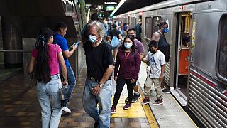 Des usagers masqués et non masqués sont vus dans une station de métro à Los Angeles, mercredi 13 juillet 2022. 