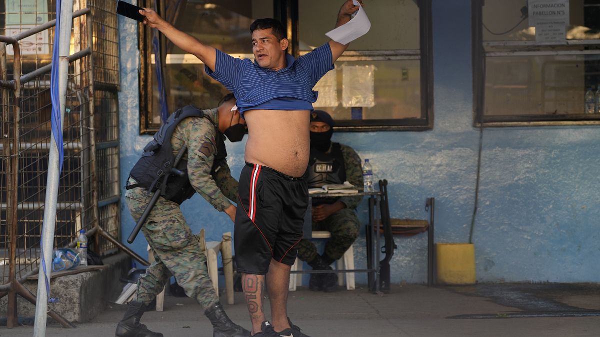 جندي يقوم بتفتيش سجين بعد أعمال شغب دامية وقعت في سجن غواياكيل 