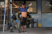 جندي يقوم بتفتيش سجين بعد أعمال شغب دامية وقعت في سجن غواياكيل