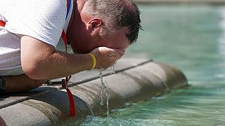 Un uomo si rinfresca nella fontana di Trafalgar Square di Londra