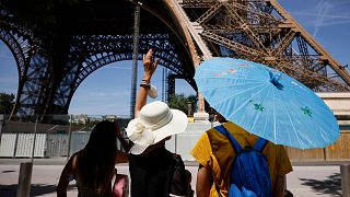 Touristes à Paris devant la Tour Eiffel - le 13 juillet 2022