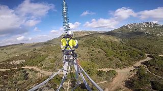Un technicien travaille sur un pylône à haute tension en Grèce