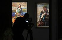 Jornalista filma o quadro de uma tibetana na exposição de Han Yuchen