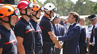 Macron stringe la mano a un pompiere