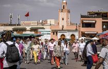 سائحون يتجولون في ساحة جامع الفناء في مراكش المغربية يوم 12 مايو 2022.