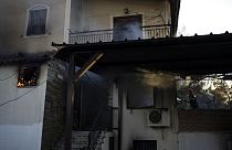 Un bombero trata de extinguir un incendio en una casa cerca de la ciudad de Megara, al oeste de Atenas, Grecia, el miércoles 20 de julio de 2022