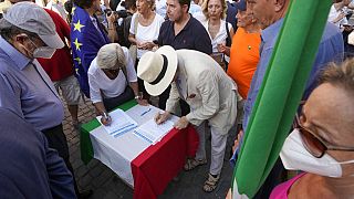 Des Italiens signent une pétition pendant une manifestation pour inciter Mario Draghi à rester à son poste de premier ministre,  lundi 18 juillet