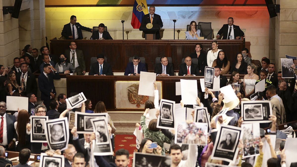 Legisladores sostienen fotos de personas desaparecidas durante el conflicto interno de Colombia en el Congreso en Bogotá, Colombia, el miércoles 20 de julio de 2022.