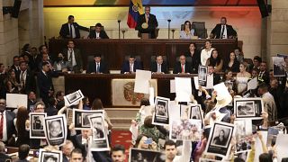 Legisladores sostienen fotos de personas desaparecidas durante el conflicto interno de Colombia en el Congreso en Bogotá, Colombia, el miércoles 20 de julio de 2022.