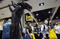 Des visiteurs de la convention observent une réplique taille réelle d'un monstre de la série de films  "Alien".