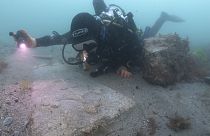 Diver with a decorated Purbeck stone gravestone on the 13th century Mortar Wreck, Poole Bay, Dorset.