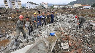 Ezen a 2016. szeptemberi képen észak-koreai munkások takarítják a romokat az áradásokban megsemmisült Onszong város egyik negyedében
