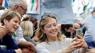 Aşırı sağcı İtalya'nın Kardeşleri Partisi (FdI) lideri Giorgia Meloni, taraftarlarıyla selfie çekerken. (Meloni, cep telefonuyla kendisi fotoğraf çekiyor)