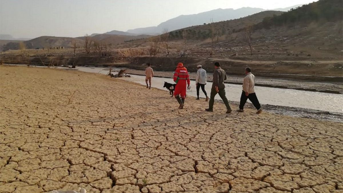  rescue workers searching near a river bank after flooding in Estahban county in souther Iran.