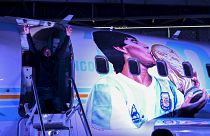  رجل يقف لالتقاط صورة في الطائرة المسماة "Tango D10S" المرسومة بصور نجم كرة القدم الراحل مارادونا، مطار مورون، مقاطعة بوينس آيرس، الأرجنتين، 23 تموز 2022