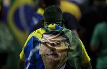 Jair Bolsonaro egyik támogatója a brazil elnököt ábrázoló törülközővel a hátán.