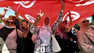 Manifestantes tunecinos izan una bandera el 23 de julio de 2022, durante una manifestación a lo largo de la avenida Habib Bourguiba en la capital, Túnez
