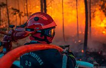 A firefighter at work at a forest fire at La Teste-de-Buch, southwestern France, late Monday, July 18, 2022.