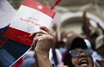 متظاهر يحمل نسخة من الدستور التونسي خلال احتجاج على الرئيس التونسي قيس سعيد في تونس العاصمة، السبت 18 سبتمبر 2021.
