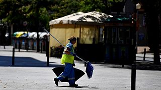 Uma mulher, varredora de rua, caminha na rua L'Hospitalet del Llobregat, perto de Barcelona, a 19 de julho de 2022. Espanha