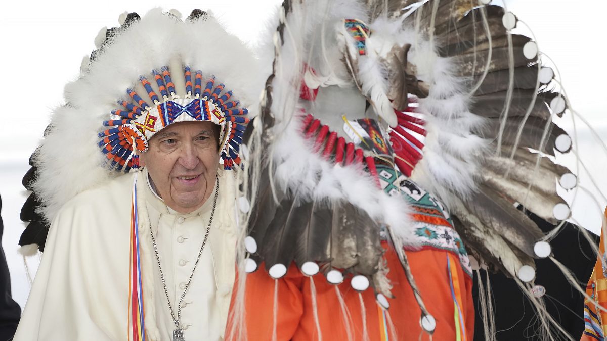 Pope Francis wears a traditional headdress he was given after his apology to Indigenous people as part of his papal visit across Canada on Monday, July 25, 2022.