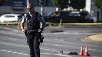 An RCMP officer stands on a median at the scene of a shooting in Langley near Vancouver, 25 July 2022