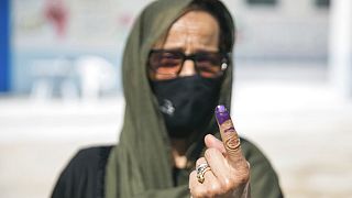 Une femme montre son doigt encré après avoir voté à l'Ariana, près de Tunis, en Tunisie, lundi 25 juillet 2022.