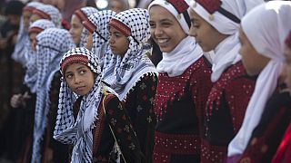 فتيات فلسطينيات يرتدين الفساتين التقليدية في مظاهرة بمناسبة يوم العادات التقليدية الفلسطينية، في مدينة غزة، الثلاثاء 30 يوليو 2019