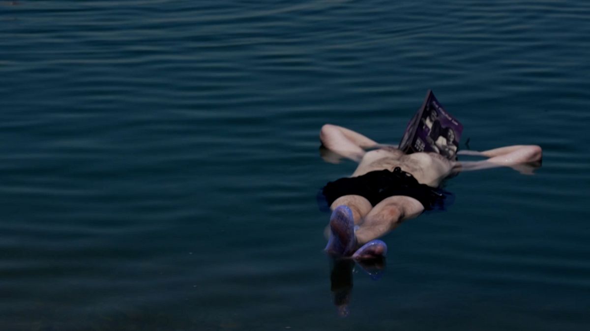 Jury member floating on the Dead Sea, reading the festival catalog, July 25, 2022.