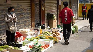 Une vendeuse attend patiente devant son étal. Son marché a Wuhan a été partiellement fermé à cause de la pandémie. Avril 2020