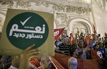 تونسي يحمل لافتة كتب عليها "نعم للدستور الجديد" احتفالا باستطلاعات الرأي التي تشير إلى التصويت لصالح الدستور الجديد، في تونس العاصمة، الإثنين 25 يوليو / تموز 2022