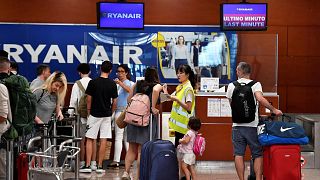 A Ryanair employee talks to a passenger at the check-in counters in Terminal 2 of El Prat airport in Barcelona.