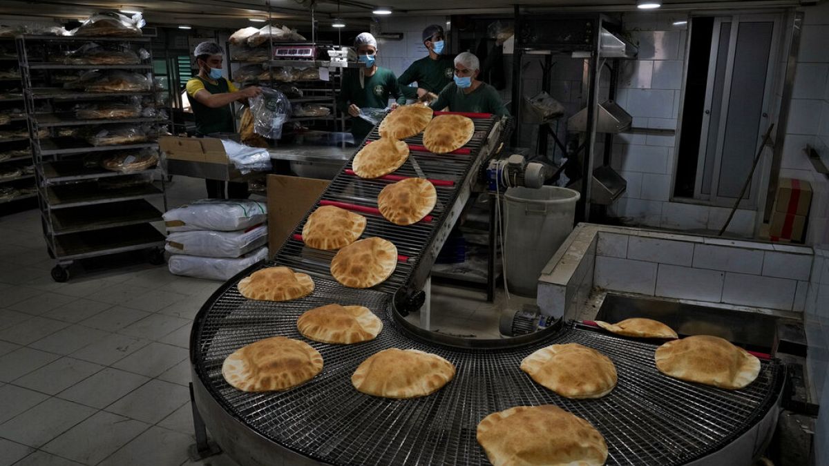عمال مخابز يقومون بتعبئة الخبز الطازج في مخبز آلي في الضاحية بجنوب بيروت، لبنان، الثلاثاء 15 مارس 2022.