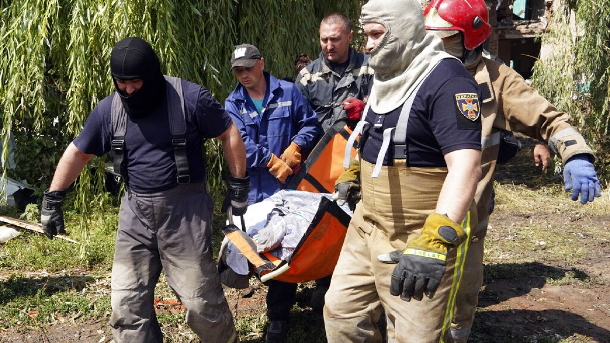 Rescuers move a covered body of a woman killed by Russian missile attack on Monday in Chuhuiv, Kharkiv region, Ukraine, Tuesday, July 26, 2022.