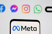 Facebook's rebrand logo Meta is seen on a smartphone in front of the logos of Facebook, Messenger, Intagram, WhatsApp, Oculus in this file photo taken October 28, 2021.